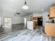Open concept living room with a ceiling fan, gray tile flooring, and adjacent kitchen area, perfect for gatherings at 2019 Newtown Rd, Groveland, FL 34736