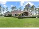 Exterior showcasing a manicured lawn, a private pool, patio with outdoor seating, and verdant landscape, offering serene views at 23247 Lake Seneca Rd, Eustis, FL 32736