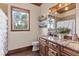 Bathroom with granite countertops, wood cabinets, decorative shelves and a large window view at 23247 Lake Seneca Rd, Eustis, FL 32736