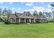 Inviting single story home featuring an expansive lawn, rocking chair front porch, and neutral exterior at 23247 Lake Seneca Rd, Eustis, FL 32736
