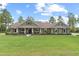 Inviting single story home featuring an expansive lawn, rocking chair front porch, and neutral exterior at 23247 Lake Seneca Rd, Eustis, FL 32736