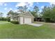 Exterior view of the detached garage featuring a neutral exterior, lush landscaping, and ample parking, offering both style and functionality at 23247 Lake Seneca Rd, Eustis, FL 32736