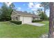 A detached garage featuring a neutral exterior, lush landscaping and a spacious driveway adding curb appeal to the property at 23247 Lake Seneca Rd, Eustis, FL 32736