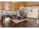 Open concept living room featuring a stone fireplace, stained concrete floors, and wood plank ceiling at 23247 Lake Seneca Rd, Eustis, FL 32736
