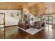 Spacious living room featuring a stone fireplace, stained concrete floors, and wood plank ceiling at 23247 Lake Seneca Rd, Eustis, FL 32736