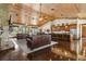 Open concept living room featuring a stone fireplace, kitchen with bar seating, and wood plank ceilings at 23247 Lake Seneca Rd, Eustis, FL 32736