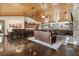 Expansive living room featuring leather furniture, a stone fireplace, and an open floor plan to the kitchen and dining area at 23247 Lake Seneca Rd, Eustis, FL 32736