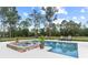 Gorgeous swimming pool with a jacuzzi, framed by lush greenery and mature trees, creating a serene oasis at 23247 Lake Seneca Rd, Eustis, FL 32736