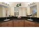 Spacious bathroom featuring dual vanities with granite countertops and large mirrors at 2400 Pawtucket Pass, Mount Dora, FL 32757