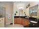 Bright bathroom featuring dual vanities, granite counters, walk-in shower, and neutral tile flooring at 2400 Pawtucket Pass, Mount Dora, FL 32757