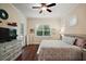 Comfortable bedroom features wood floors, white dresser and view of the outside at 2400 Pawtucket Pass, Mount Dora, FL 32757
