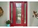 Elegant red front door with decorative glass panels and stylish hardware accents at 2400 Pawtucket Pass, Mount Dora, FL 32757
