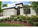 Beautifully landscaped front yard with lush greenery and a modern home exterior at 2400 Pawtucket Pass, Mount Dora, FL 32757
