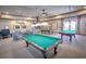Well-lit game room with multiple billiard tables and comfortable seating area at 2400 Pawtucket Pass, Mount Dora, FL 32757