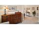 Hallway view features a wooden dresser with decorative lamp and artwork adorning the walls at 2400 Pawtucket Pass, Mount Dora, FL 32757
