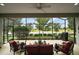Screened patio overlooking serene lake view with outdoor seating and grill at 2400 Pawtucket Pass, Mount Dora, FL 32757