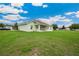 A wide view of the backyard showing an expansive lawn and the back of the house at 2495 Se 75Th Blvd, Bushnell, FL 33513