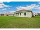 An expansive backyard and the home's rear exterior with light green siding and white trim at 2495 Se 75Th Blvd, Bushnell, FL 33513