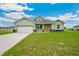 Charming single-story home with a two-car garage, lush green lawn, and bright yellow front door at 2495 Se 75Th Blvd, Bushnell, FL 33513