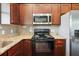 Close-up of a modern kitchen with stainless steel appliances and dark wood cabinetry at 2495 Se 75Th Blvd, Bushnell, FL 33513