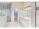 Bright bathroom featuring a dual sink vanity, a walk-in shower, and a separate tub at 25025 Cranes Roost Cir, Leesburg, FL 34748
