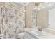 Bright bathroom featuring floral wallpaper and a shower and bathtub combo at 25025 Cranes Roost Cir, Leesburg, FL 34748