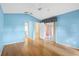 An inviting bedroom featuring hardwood floors, bright blue painted walls, and a ceiling fan at 25025 Cranes Roost Cir, Leesburg, FL 34748