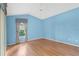 An inviting bedroom featuring hardwood floors and a bright blue painted wall at 25025 Cranes Roost Cir, Leesburg, FL 34748