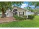 Charming single-story home featuring a screened porch, well-kept landscaping, and a welcoming facade at 25025 Cranes Roost Cir, Leesburg, FL 34748