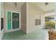 Up close view of the front porch and glass adorned green front door at 25025 Cranes Roost Cir, Leesburg, FL 34748