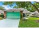 Charming single-story home with a green garage door, brick accents and well-maintained lawn at 25025 Cranes Roost Cir, Leesburg, FL 34748