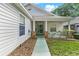 Covered front porch with green door, classic brick accents, and well maintained landscaping at 25025 Cranes Roost Cir, Leesburg, FL 34748
