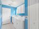 Bright blue laundry room with white cabinets, sink, and a washer and dryer at 25025 Cranes Roost Cir, Leesburg, FL 34748