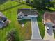 Aerial view of a neatly landscaped home with a patterned driveway and screened lanai at 2557 Privada Dr, The Villages, FL 32162
