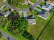 Aerial view of home highlighting lush lawn, surrounding trees, and neighboring properties at 2557 Privada Dr, The Villages, FL 32162