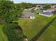 Aerial view of a spacious backyard with lush grass, mature trees, and a screened-in porch at 2557 Privada Dr, The Villages, FL 32162