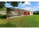 Home exterior view with a screened patio and sunroom, set in a well-maintained, spacious backyard at 2557 Privada Dr, The Villages, FL 32162