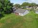 Aerial view of the rear of home showcasing a large grassy backyard and screened patio at 2557 Privada Dr, The Villages, FL 32162