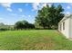 Expansive green backyard featuring mature trees and a well-maintained lawn, perfect for outdoor enjoyment at 2557 Privada Dr, The Villages, FL 32162