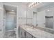 Bathroom features a granite countertop vanity, large mirror, and walk-in shower at 2557 Privada Dr, The Villages, FL 32162