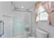 Bathroom featuring a walk-in shower with glass door and tile at 2557 Privada Dr, The Villages, FL 32162