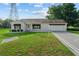 Charming single-story home with a well-manicured lawn, black awnings, and an attached garage at 2557 Privada Dr, The Villages, FL 32162