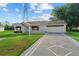 Attractive home featuring a long, decorative driveway and well-kept lawn at 2557 Privada Dr, The Villages, FL 32162