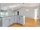 View of kitchen island with granite countertop, overlooking dining area with laminate floors at 2557 Privada Dr, The Villages, FL 32162