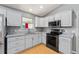 Updated kitchen boasts stainless steel appliances and plenty of gray cabinet space at 2557 Privada Dr, The Villages, FL 32162