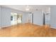 Bright living room featuring wood floors, ceiling fan, and sliding glass doors at 2557 Privada Dr, The Villages, FL 32162