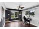 Functional office with a ceiling fan, dark wood floors, and natural light from the two windows at 2610 Florence Dr, Kissimmee, FL 34744