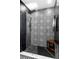 Modern tiled shower with a glass door, rainfall shower head, and patterned black and white design at 2610 Florence Dr, Kissimmee, FL 34744