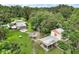 Aerial view of multiple homes surrounded by lush landscaping with driveways and green lawns at 27113 Robertson Rd, Yalaha, FL 34797