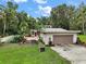 Property featuring an in-ground pool, garage, and lush landscaping, ideal for outdoor living and entertaining at 27113 Robertson Rd, Yalaha, FL 34797